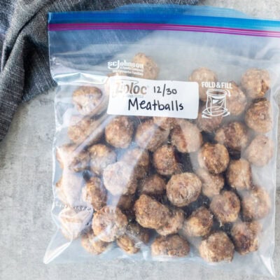 Frozen meatballs in a Ziplock freezer bag that has been labeled and dated and ready to be reheated.