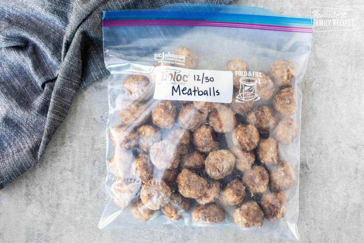 Frozen meatballs in a Ziplock freezer bag that has been labeled and dated and ready to be reheated.