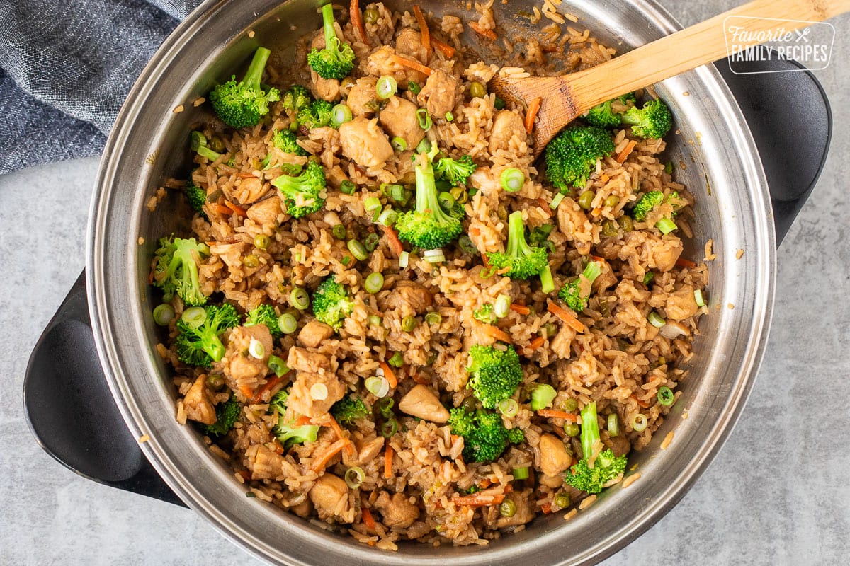 Cooked skillet of One Pot Teriyaki Chicken Bowls with wooden spoon.