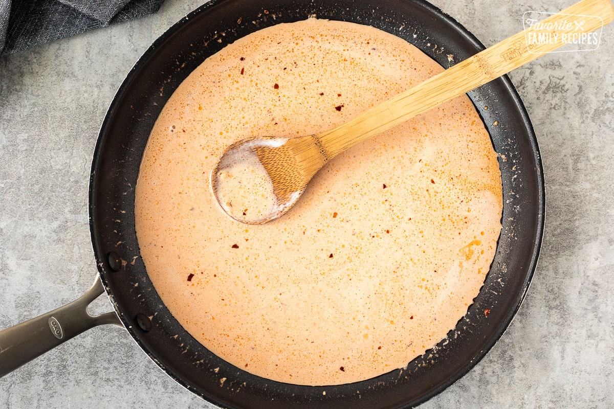 Skillet with cream base for ravioli sauce.