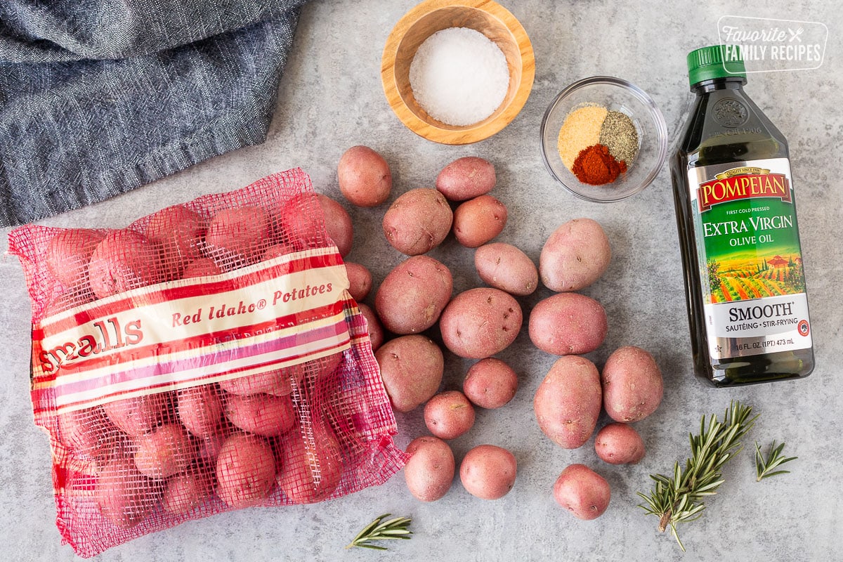 Ingredients to make Roasted Red Potatoes including red potatoes, seasonings, salt and olive oil.