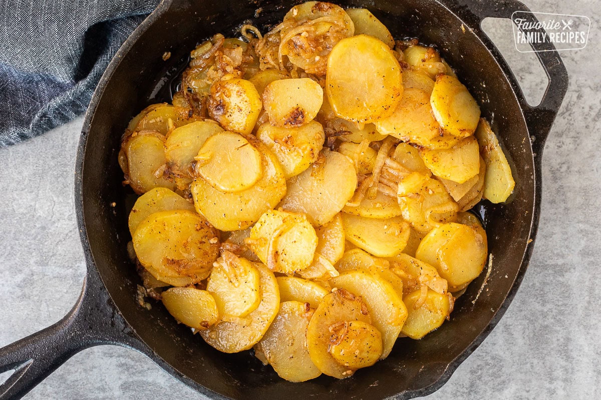 Skillet with cooked potatoes and caramelized onions.