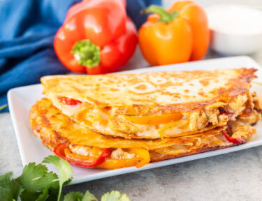 Two chicken quesadillas stacked on a plate.