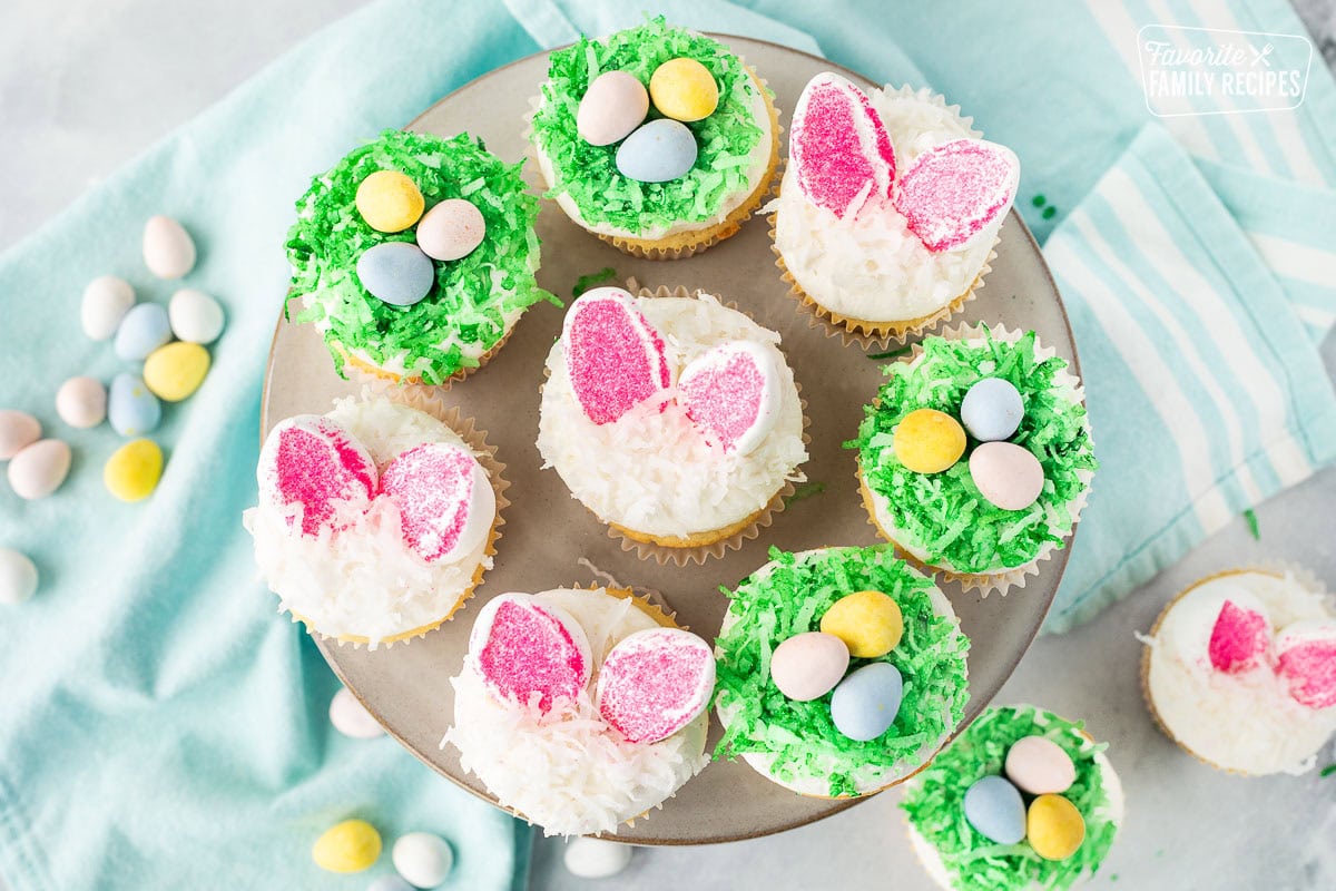 Easter cupcakes on a cake stand shaped like bunny ears and birds nests.