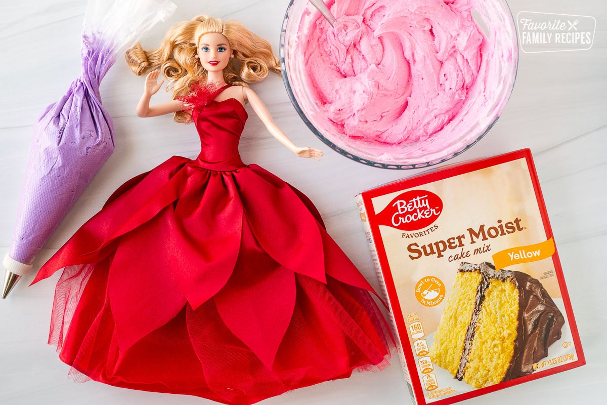 Ingredients to make a Barbie cake including frosting, Barbie and a cake mix.