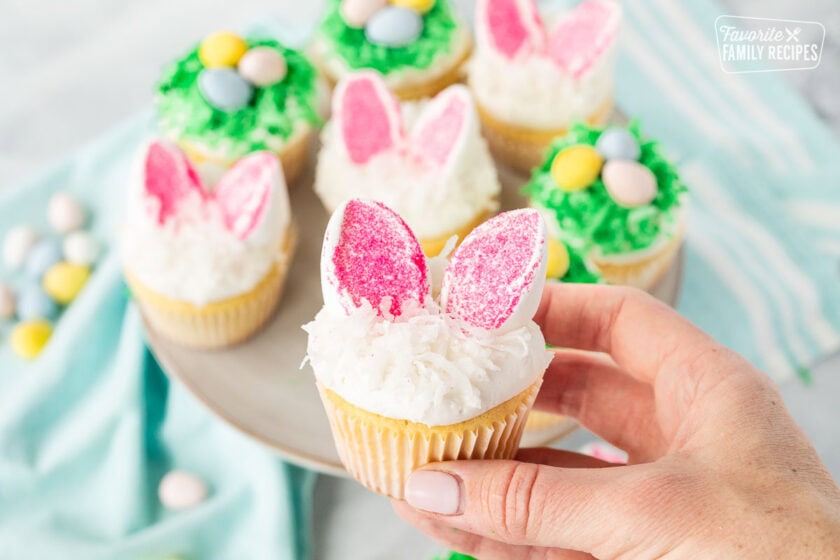 Hand holding an Easter Cupcake shaped like a bunny.