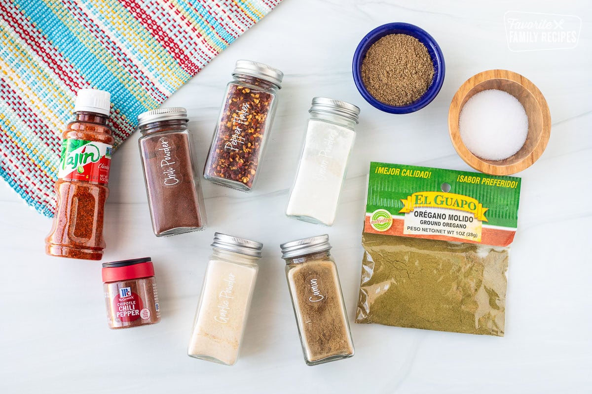 Ingredients to make Carne Asada seasoning including garlic powder, onion powder, cumin, oregano, salt, coriander, red pepper flakes, chili powder, chipotle chili Pepper powder and Tajin.