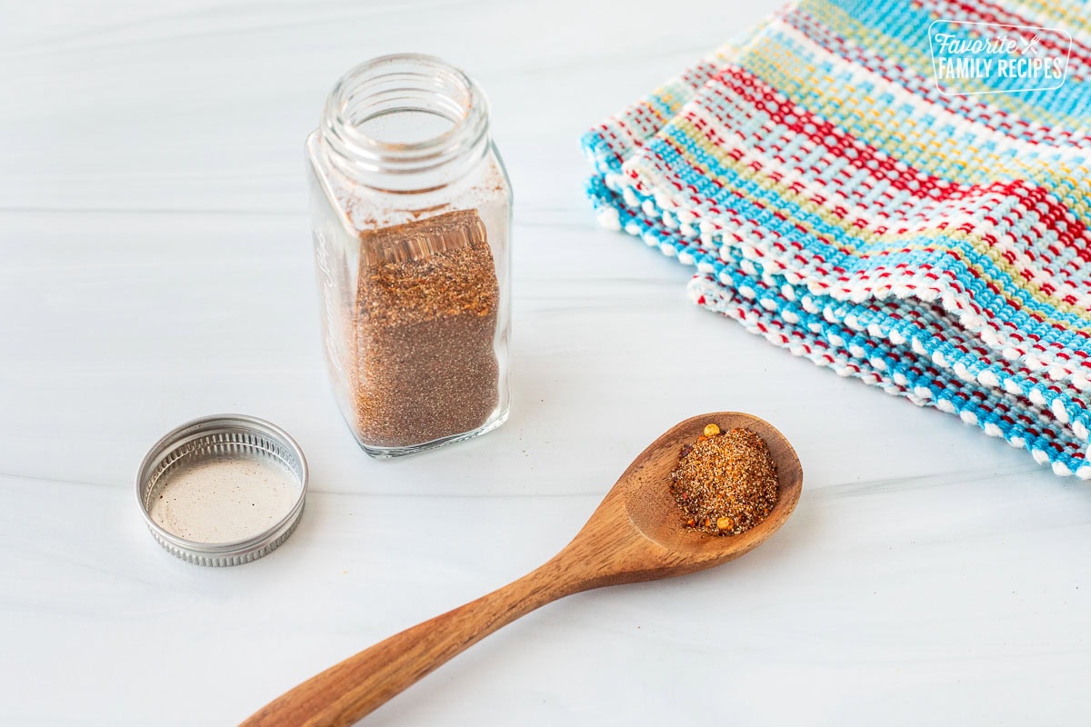 Spoon filled with Carne Asada seasoning. Small glass jar of Carne Asada seasoning on the side.