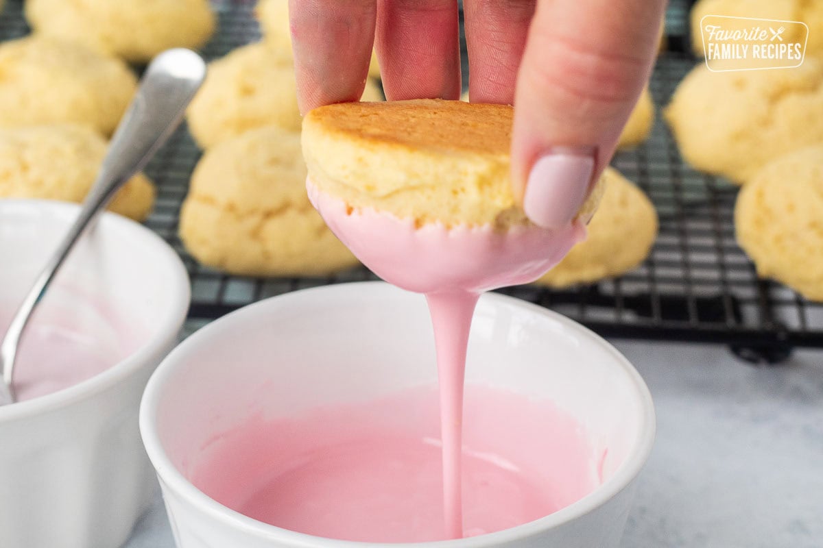 Dipping an Italian Easter cookie in pink icing.