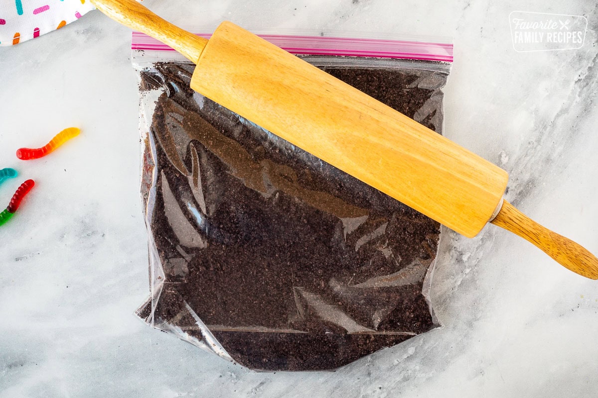 Ziplock bag with crushed Oreo cookies and a rolling pin.