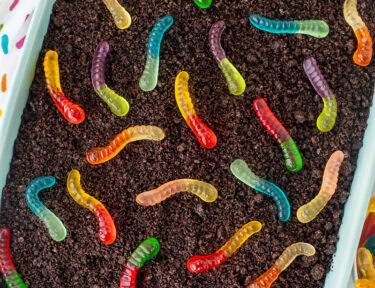 Baking dish of chocolate dirt cake with gummy worms.