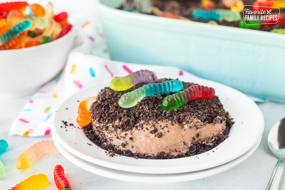 Plate with dirt cake and colorful gummy worms.