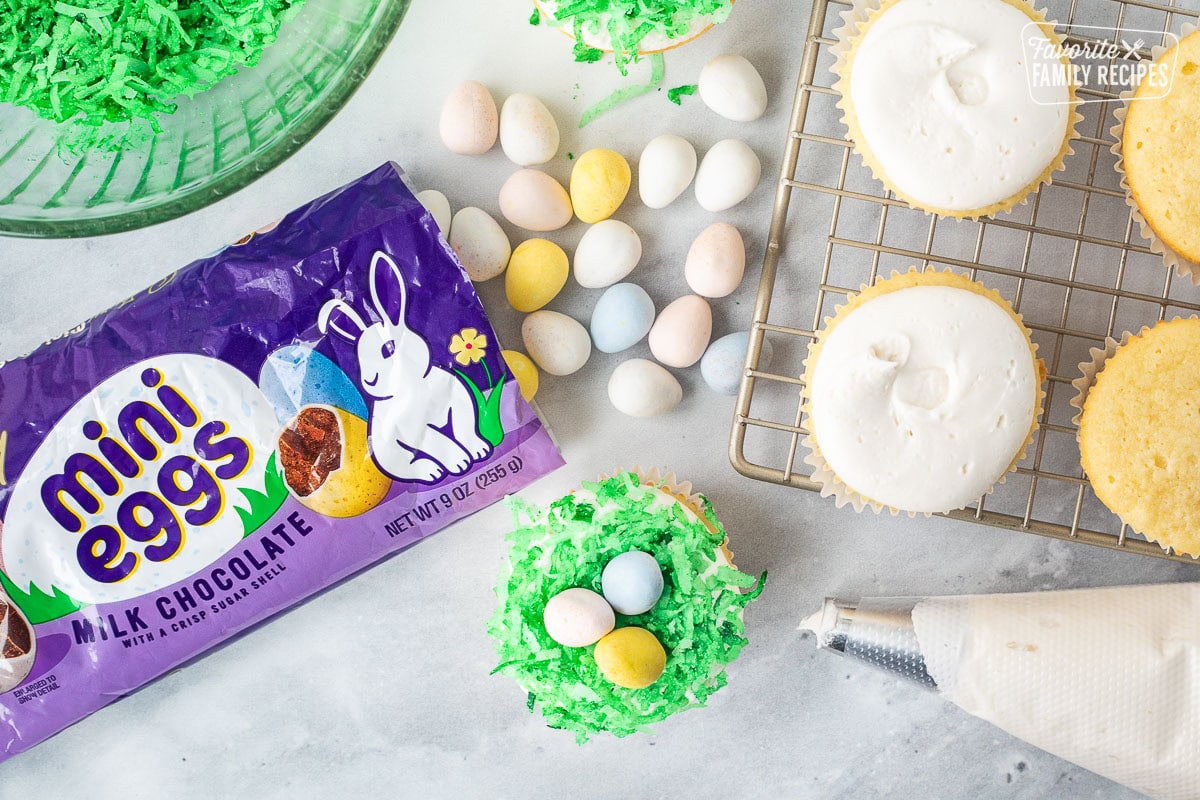 Cupcake topped with green colored coconut and mini Cadberry chocolate eggs.