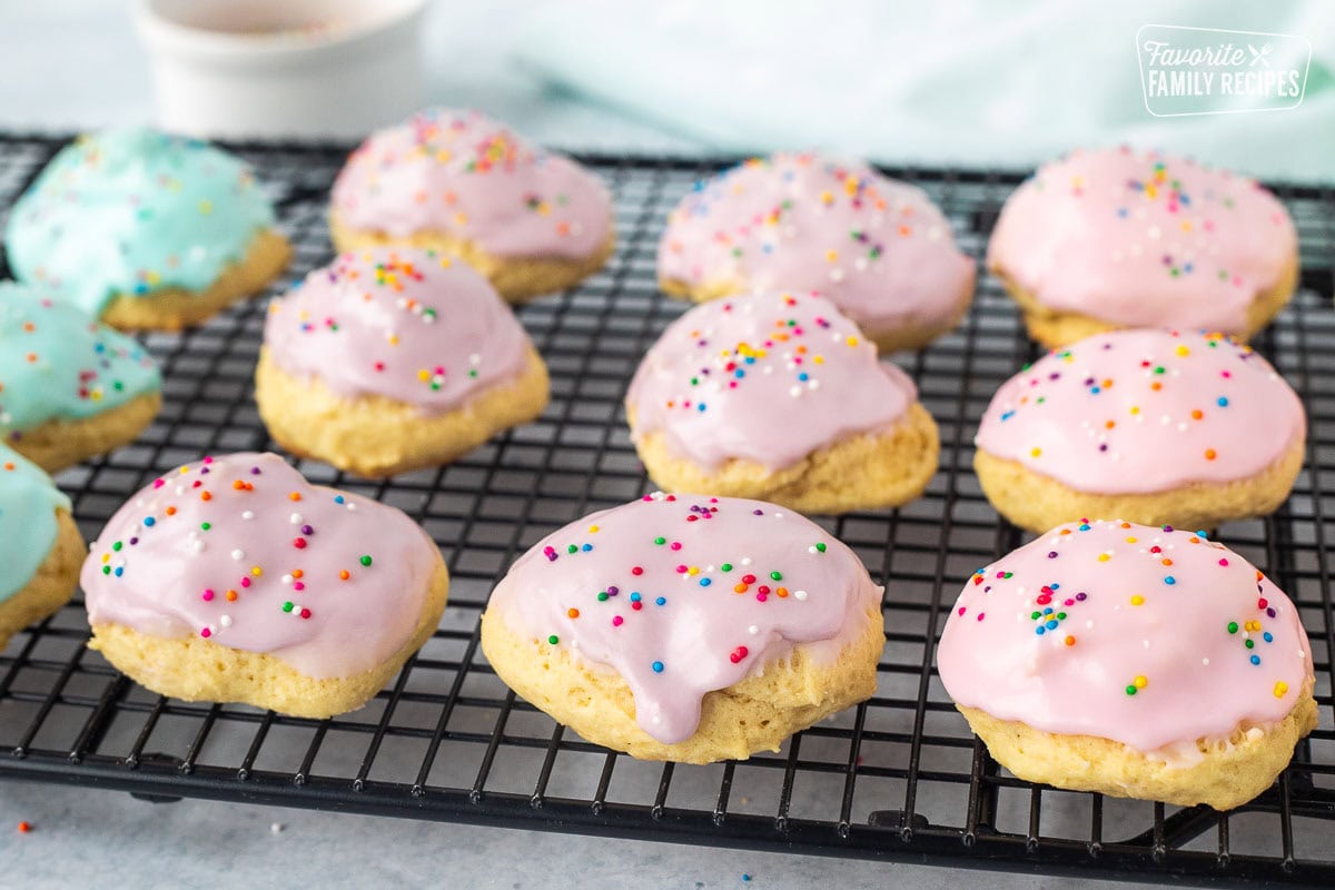 Pink, purple and blue Italian Easter cookies drying on a cooling rack.