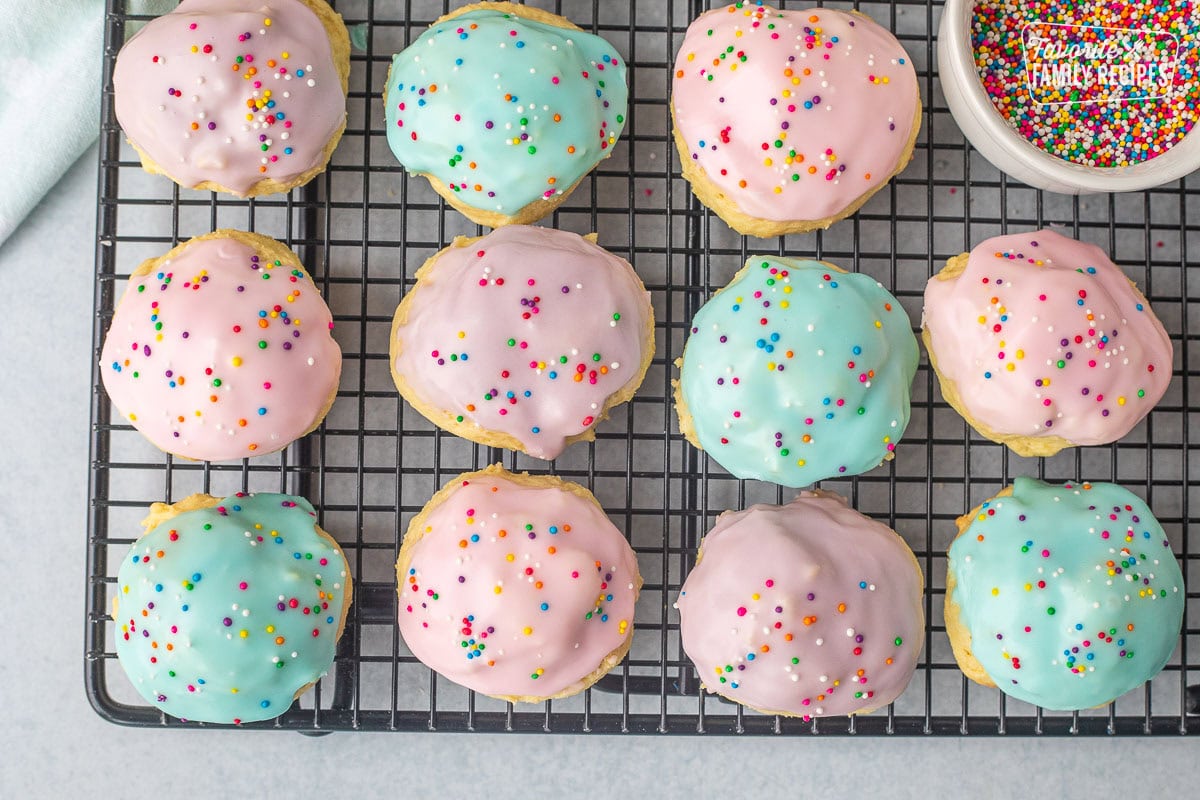 Iced Italian Easter cookies with sprinkles on a cooling rack.