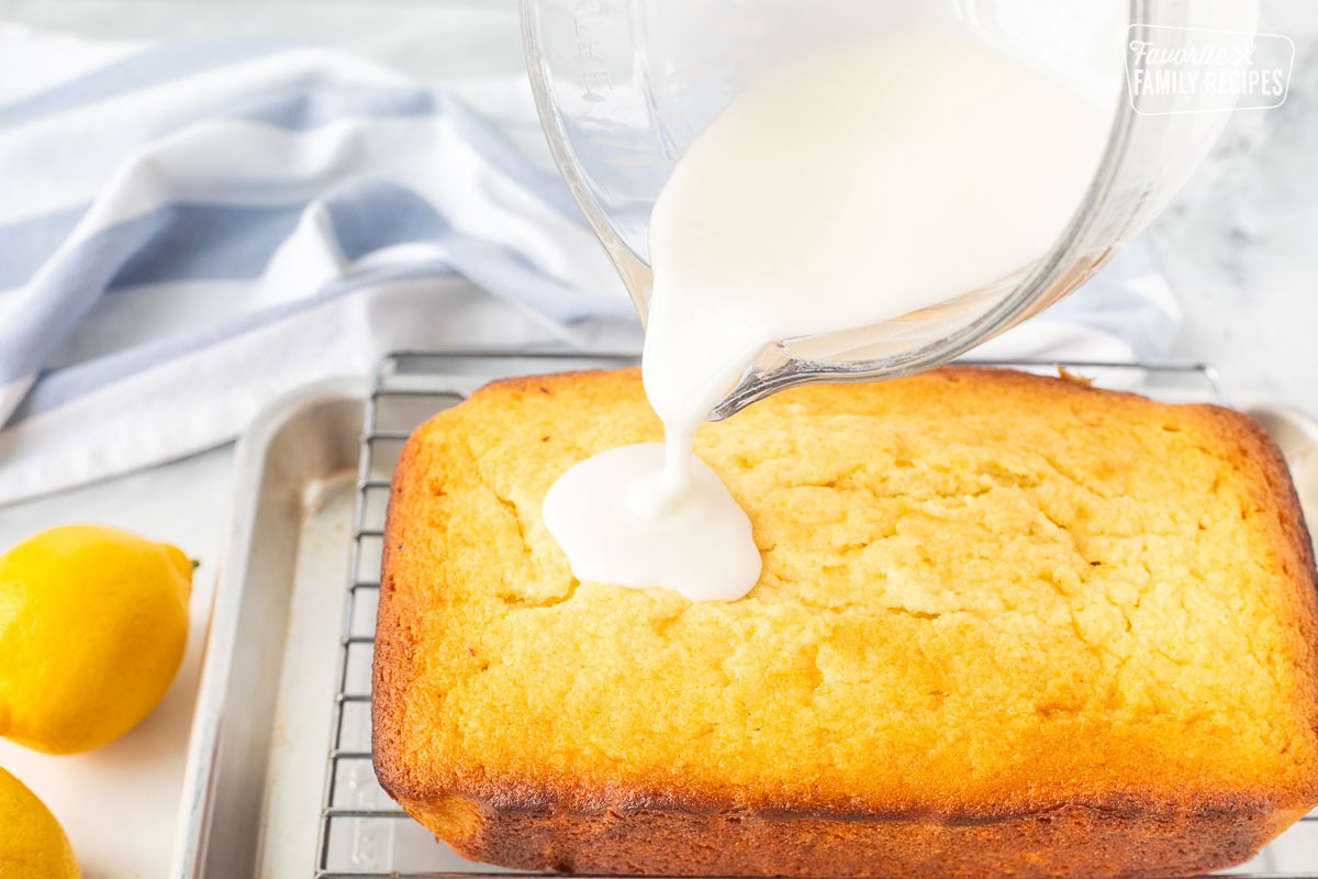 Pouring glaze on top of baked lemon pound cake.