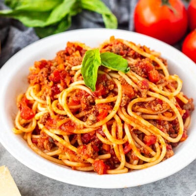 Nick's Authentic Italian Spaghetti on a plate with fresh basil leaves.