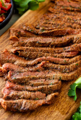 Grilled Carne Asada sliced on a cutting board. Pico de Gallo on the side.