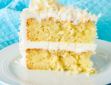 Close up of coconut cream cake with coconut frosting slice.