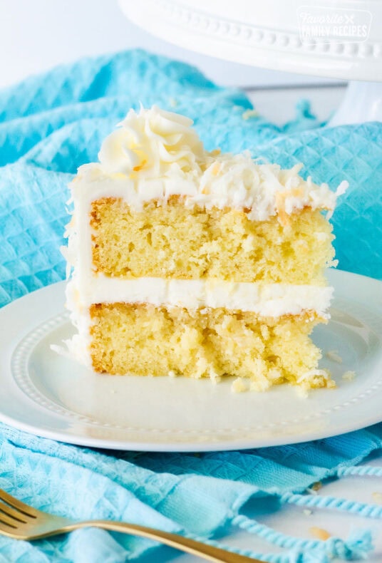 Close up of coconut cream cake with coconut frosting slice.