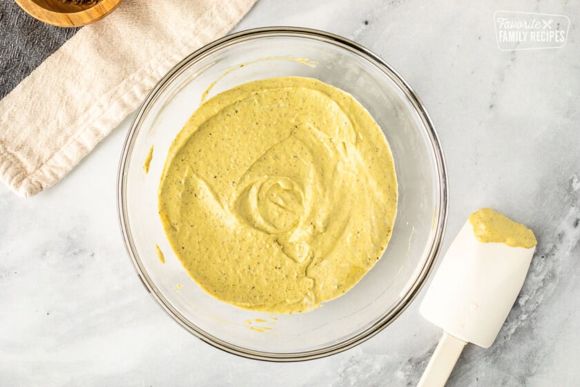 Glass bowl with pesto mayo. Spatula on the side.