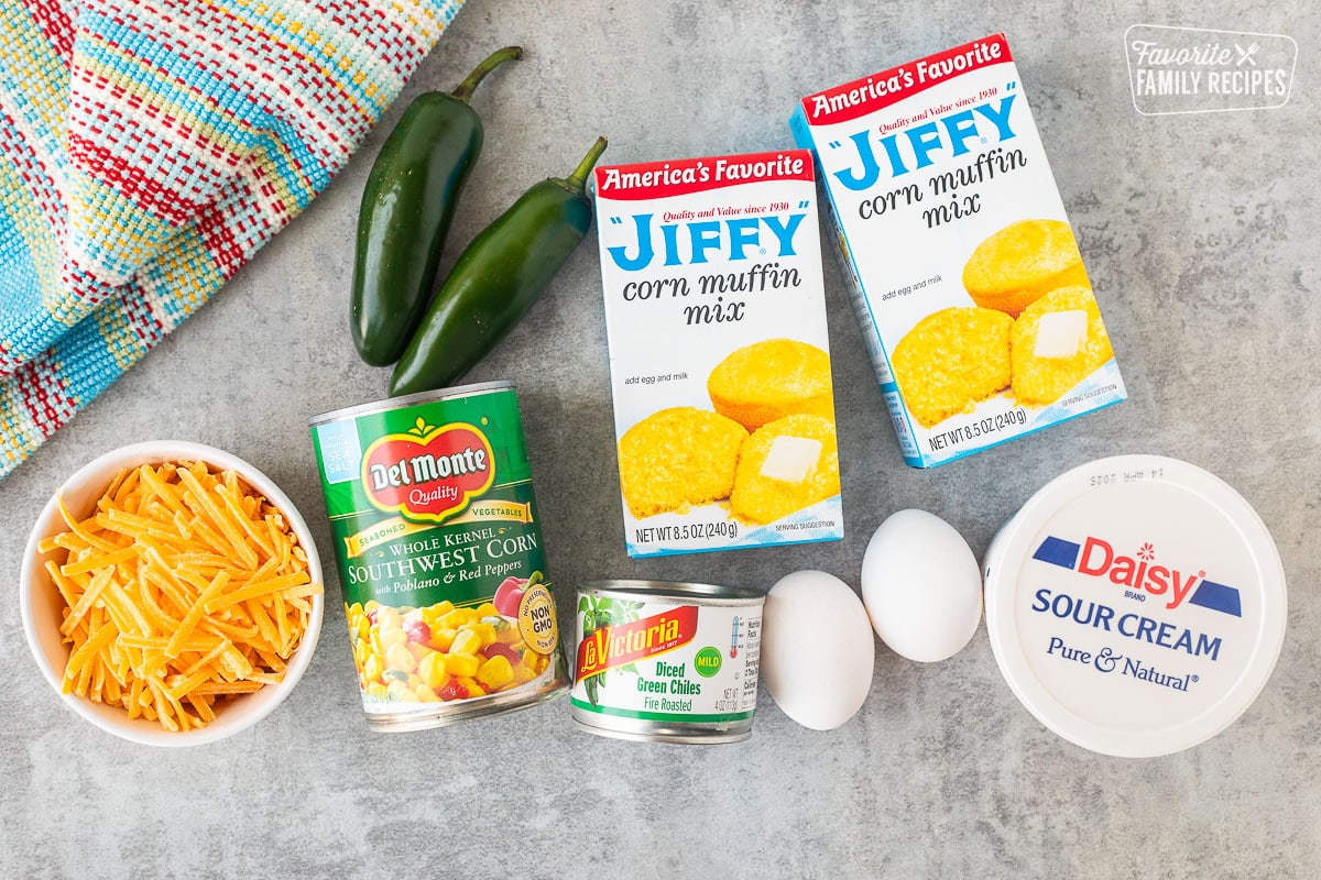 Ingredients to make Mexican Cornbread including Jiffy corn muffin mix, sour cream, eggs, diced green chilies, southwest corn, jalapeños and cheese.