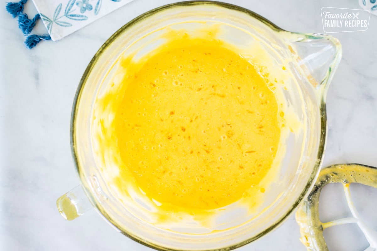 Glass mixing bowl with orange pineapple cake batter.