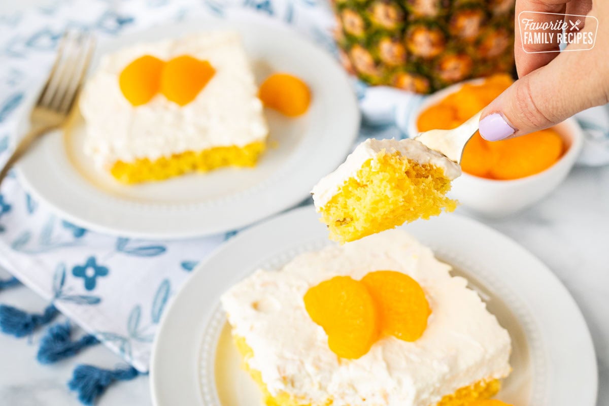 A fork holding a piece of orange pineapple cake.