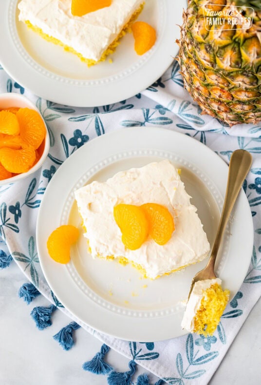 Orange pineapple cake slice on a plate with a fork.