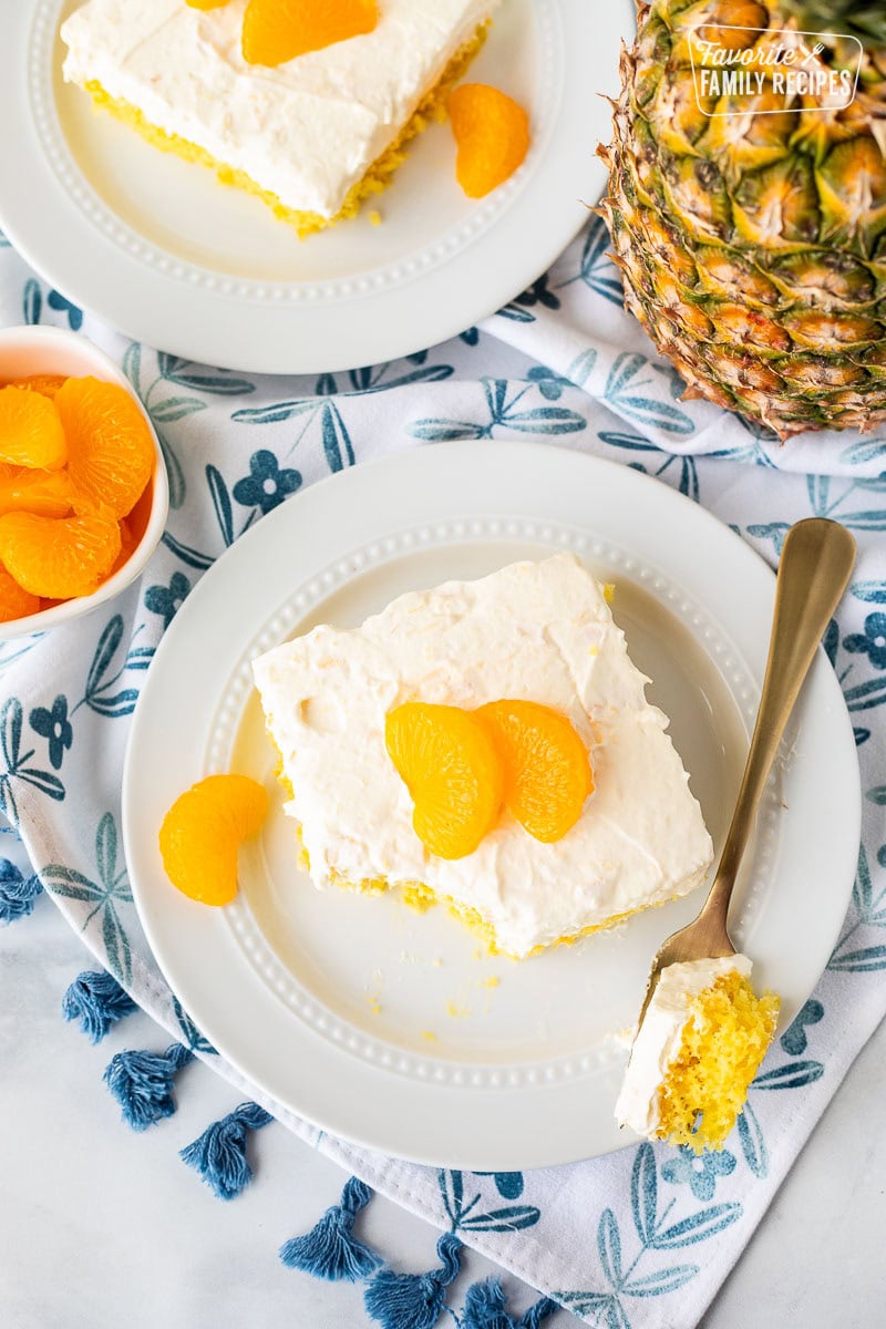 Orange pineapple cake slice on a plate with a fork.